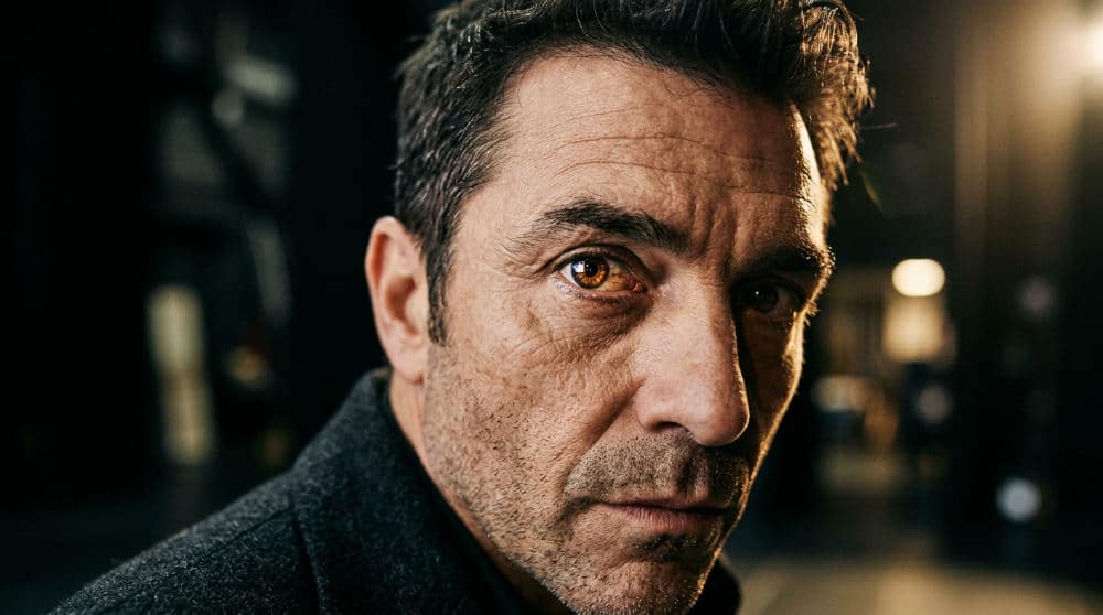 A theatrical headshot featuring a shallow depth of field and dramatic lighting to emphasize the actor's eyes.