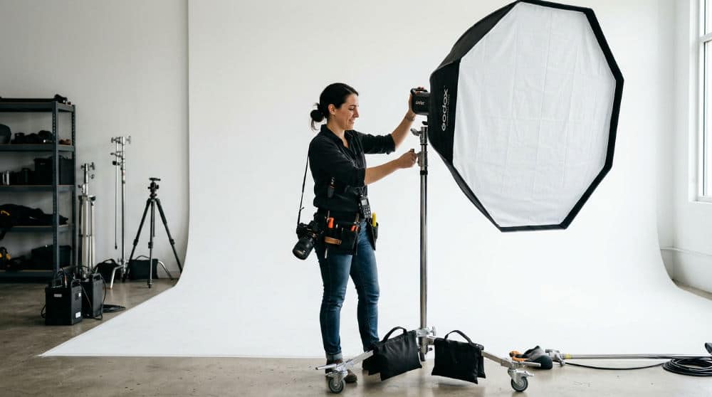 A technician adjusting professional lighting for a high-end photo shoot booth session.
