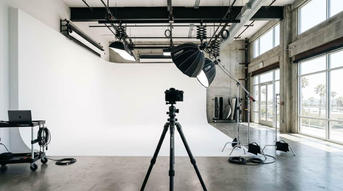 A professional San Diego photography studio featuring a large white cyclorama wall and high-end lighting equipment.