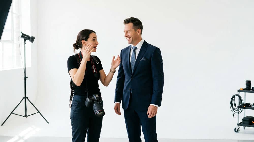 Professional photographer providing expression coaching to a client during a studio headshot session in San Diego.