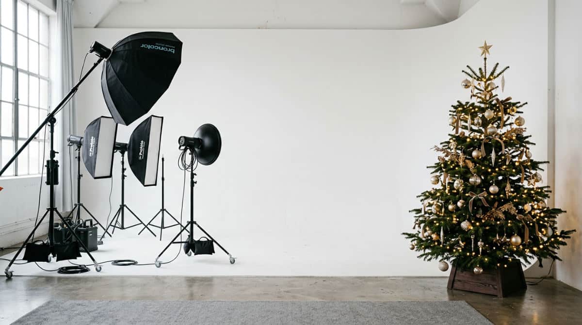 A professional San Diego photography studio featuring a white cyclorama wall and holiday decorations for a Christmas photo shoot.