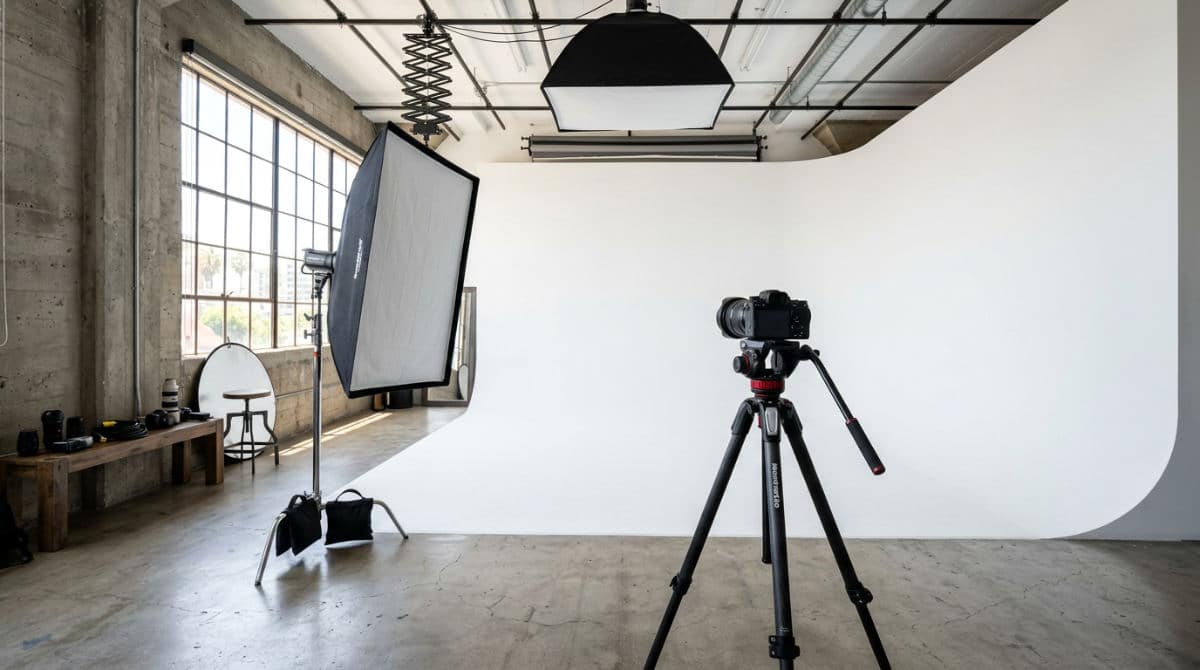 A professional San Diego photography studio setup featuring a white cyclorama wall and high-end lighting equipment for headshots.