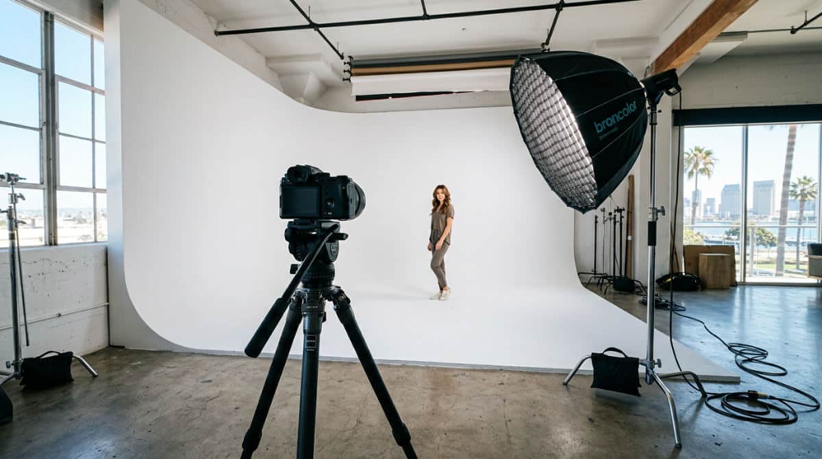 A professional San Diego photography studio with a white cyclorama wall and lighting equipment for double vision photos.
