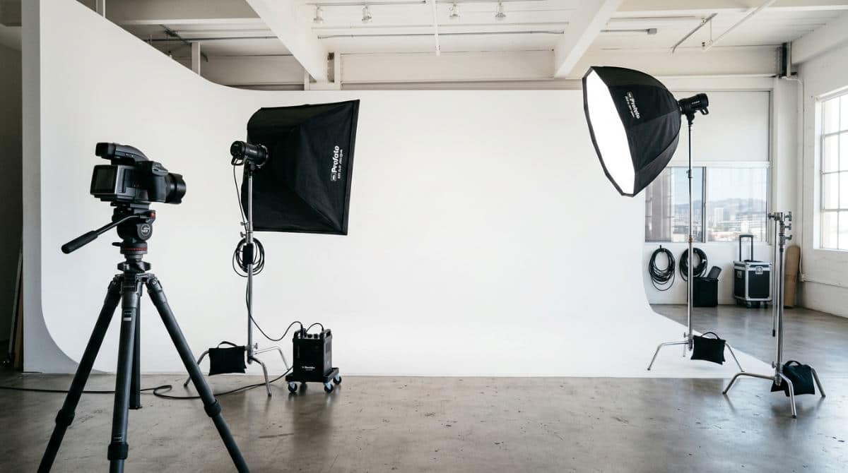A professional San Diego photography studio featuring a white cyclorama wall and high-end lighting equipment for headshots.