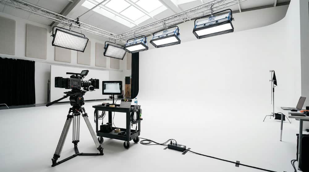 A large white cyclorama wall studio setup providing a seamless background for professional video production.