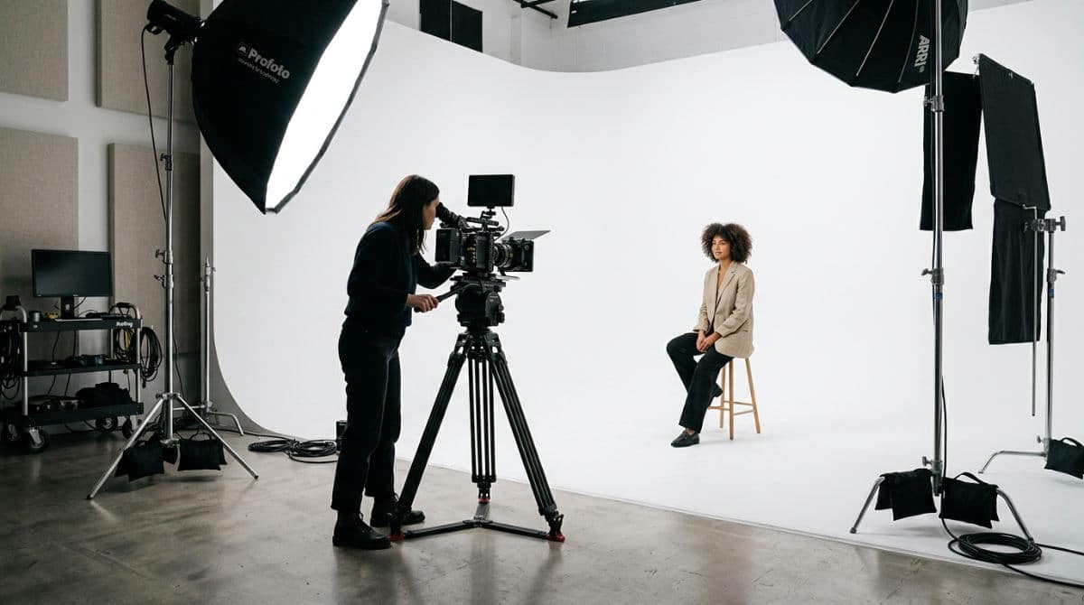 A modern professional photography studio in San Diego featuring a white cyclorama wall and professional lighting equipment.